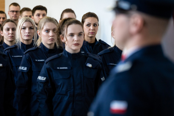nowo przyjęci policjanci i policjantki stojący w rzędach