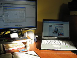 monitor komputera i stojący obok na biurku laptop