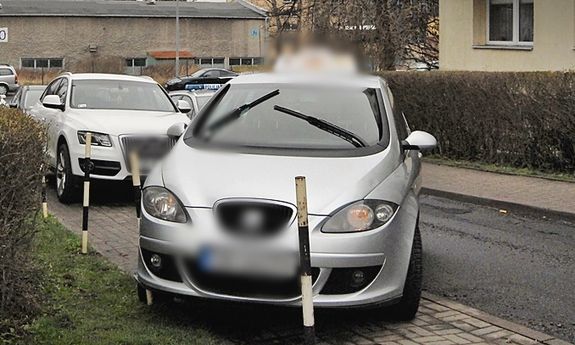 srebrny samochód osobowy, który wjechał w pachołek