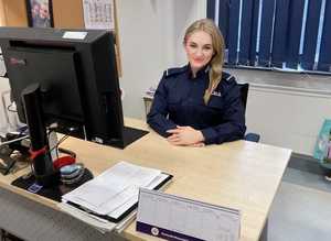 umundurowana policjantka siedzi przy biurku w pomieszczeniu