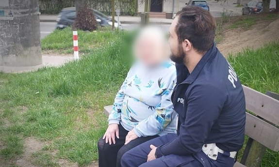 Policjant rozmawia ze starszą panią, oboje siedzą na ławce