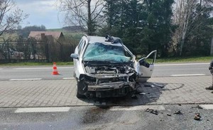 Rozbity samochód osobowy Opel od frontu, uszkodzona szyba czołowa, zderzak i maska