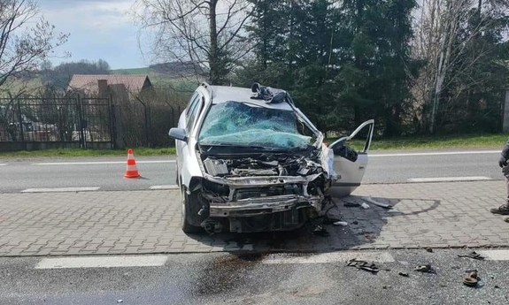 Rozbity samochód osobowy Opel od frontu, uszkodzona szyba czołowa, zderzak i maska