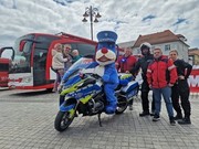 policjant na motocyklu oraz trzech mężczyzn stojących obok pojazdu