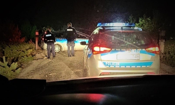 dwa radiowozy i policjanci w trakcie poszukiwań