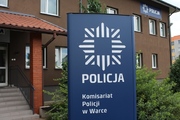 Przed budynkiem baner z napisem Policja