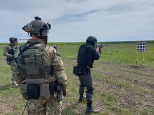 Dwaj policyjni kontrterroryści obserwują ćwiczenia strzeleckie.
