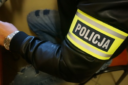 opaska  z napisem Policja na ramieniu policjanta