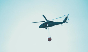 Policyjny śmigłowiec Black Hawk z podwieszonym zbiornikiem Bambi Bucket.