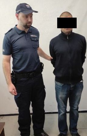 policjant prowadzi zatrzymanego mężczyznę