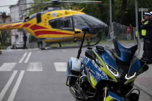 motocykl policyjny, w tle śmigłowiec  Lotniczego Pogotowia Ratunkowego