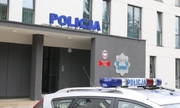 napis policja na budynku komendy policji, przed nim stoi radiowóz