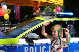 dziewczynka stoi obok radiowozu policyjnego