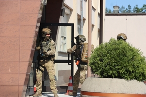 uzbrojeni kontrterroryści wchodzą do budynku