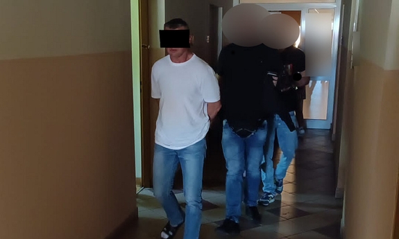 policjanci prowadzą zatrzymanego mężczyznę