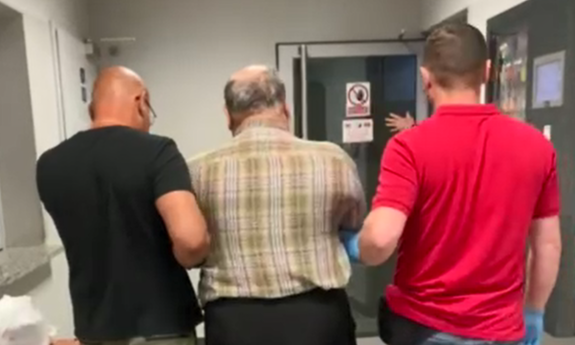 dwaj nieumundurowani policjanci prowadzą zatrzymanego