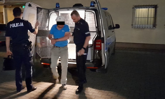 policjanci prowadzą zatrzymanego mężczyznę