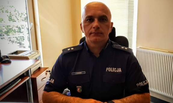 umundurowany policjant siedzi przy biurku