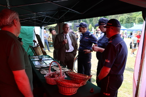 Grupa policjantów z przedstawicielami Lasów Państwowych w namiocie.