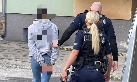 policjanci prowadzą zatrzymanego mężczyznę