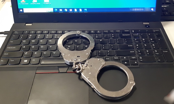 Kajdanki leżące na klawiaturze laptopa