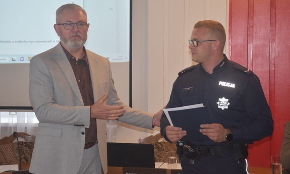 policjant  i mężczyzna w jasnym garniturze