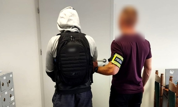 policjant z zatrzymanym mężczyzną