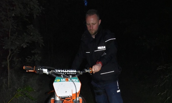 policjant trzyma za kierownice motocykl