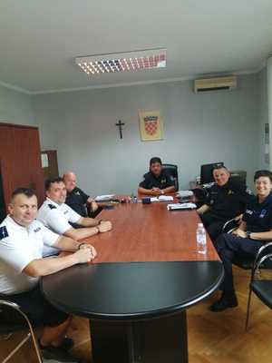 dwaj polscy policjanci w biurze chorwackiej Policji w otoczeniu chorwackich policjantów