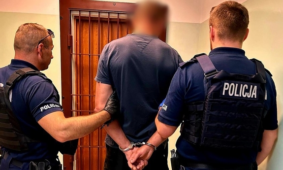 dwaj policjanci z zatrzymanym w pomieszczeniu