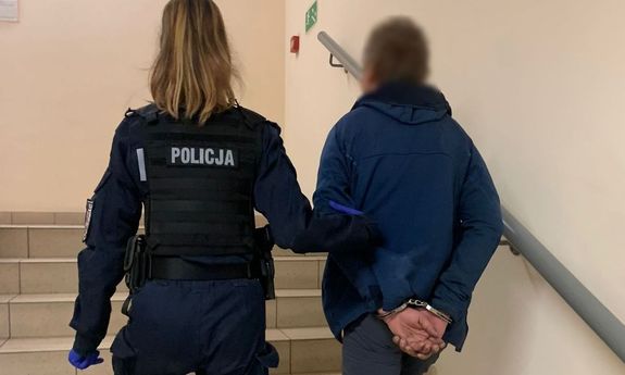 policjantka prowadzi zatrzymanego po schodach - widok z tyłu