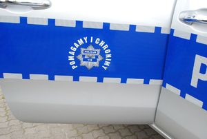 Na zdjęciu otwarte drzwi policyjnego radiowozu z logo i napisem: pomagamy i chronimy
