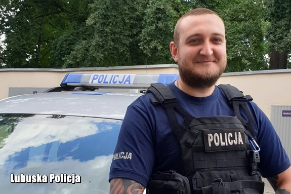 policjant stoi przy radiowozie