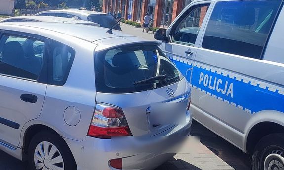 tył samochodu osobowego i stojący przy nim policyjny furgon