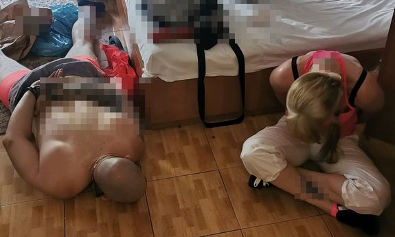 zatrzymany mężczyzna z kajdankami na ręce trzymane z tyłu, leżący twarzą do podłogi, obok zatrzymana kobieta siedząca na podłodze
