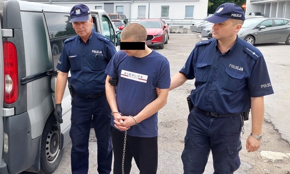 policjanci prowadzą zatrzymanego mężczyznę