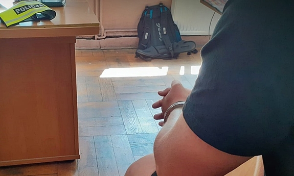 Mężczyzna siedzący na krześle z kajdankami na rękach