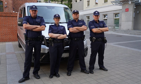 umundurowani policjanci stoją przy radiowozie