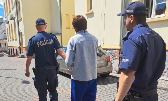 dwaj policjanci prowadzą zatrzymanego mężczyznę
