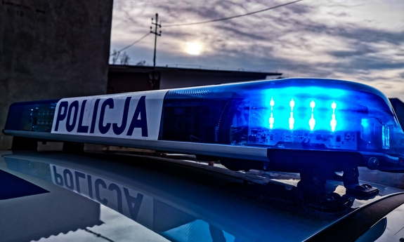 Sygnalizator świetlny na dachu radiowozu policyjnego z napisem policja