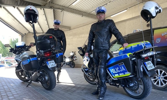 dwaj policjanci stoją przy motocyklach