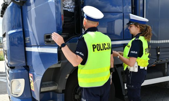 dwoje policjantów ruchu drogowego w żółtych kamizelkach kontroluje ciężarówkę