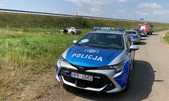 Radiowóz. W tle uszkodzony samochód