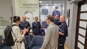 Umundurowani włoscy i polscy policjanci prowadzący rozmowę w Sali poświęconej historii polskiej Policji.