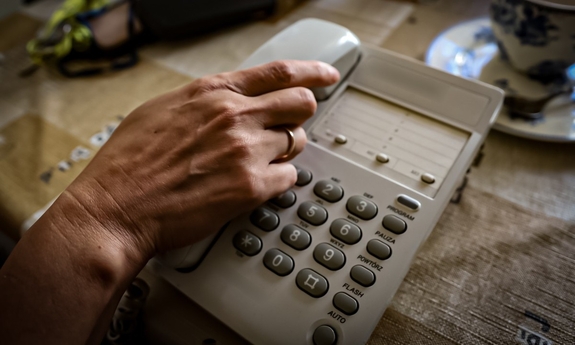 Dłoń podnosząca słuchawkę na telefonie