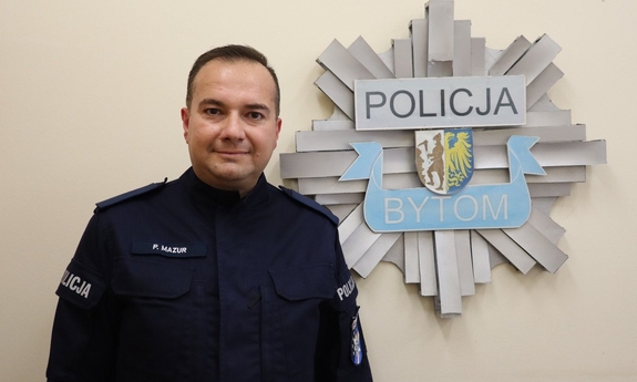 policjant posterunkowy Przemysław Mazur w tle odznaka policyjna z napisem Policja Bytom