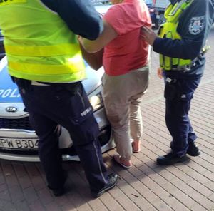 policjanci prowadzą zatrzymanego mężczyznę