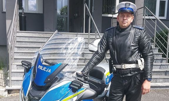 Umundurowany policjant przy policyjnym motocyklu