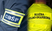 napis CBŚP na ramieniu kurtki policjanta i napis służba celno-skarbowa na plecach kamizelki mężczyzny