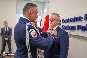 Komendant CBŚP nadinsp. Paweł Półtorzycki przypina Srebrny Medal za „Zasługi dla Policji” Thomasowi Andersenowi